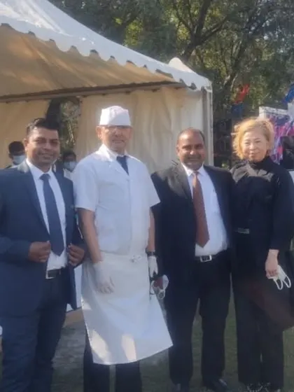 Our team on the ground. Here are some of our managers and chefs posing with a client at an outdoor event, ensuring everything runs perfectly.