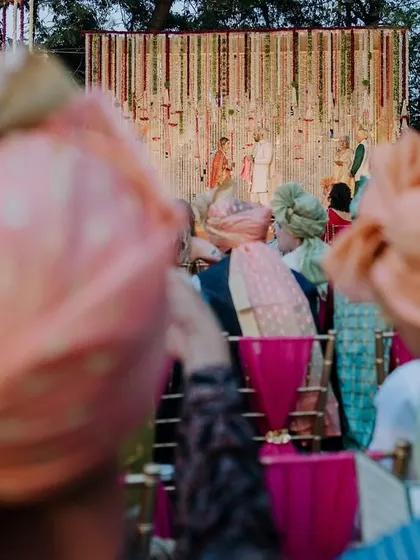 A creative shot from the back of the crowd, showing the guests' colorful turbans as they watch the ceremony. This offers a unique perspective of the event.