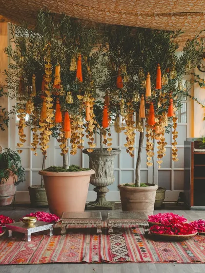 A sunny Haldi ceremony in the British countryside, with details like "Love is all we need" henna, fresh yellow flowers, and bowls of rose petals.