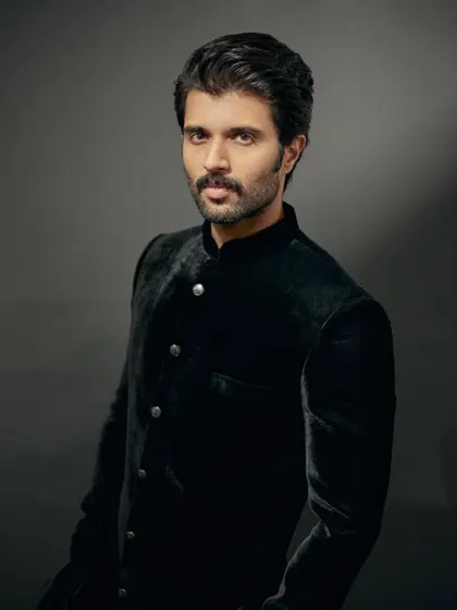 A close-up portrait of Vijay. The velvet bandhgala provides a rich texture that exudes luxury.