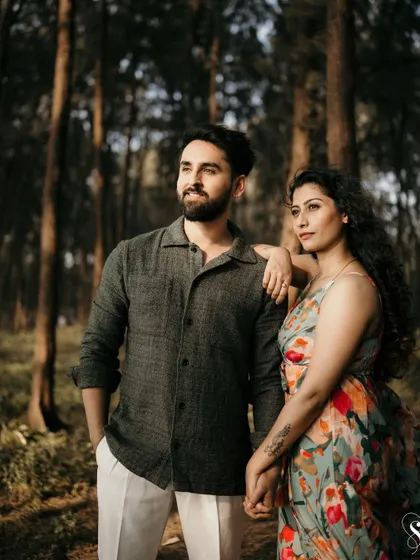 Looking towards the future, together. This candid portrait in the woods captures a moment of shared dreams and quiet confidence between the couple.