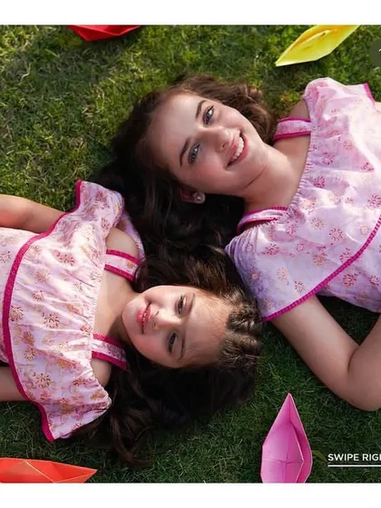 An overhead shot from the Aurelia campaign, featuring two young models. The makeup is minimal and clean, focusing on clear skin and neat hair to create a wholesome and joyful image.
