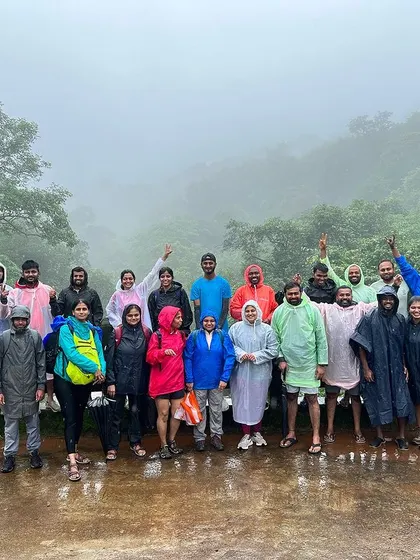 A group photo in our raincoats at Rajmachi Fort. The rain and fog are all part of the monsoon experience.