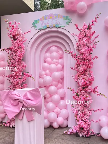 A detailed look at the 'Pop of Pink' backdrop, with a large bow centerpiece and beautiful floral columns.