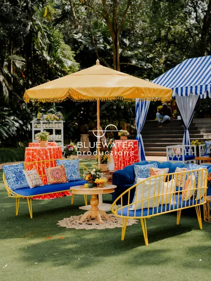 We love mixing and matching. Here, a blue and white striped cabana complements the yellow and blue seating area for a playful, eclectic look.