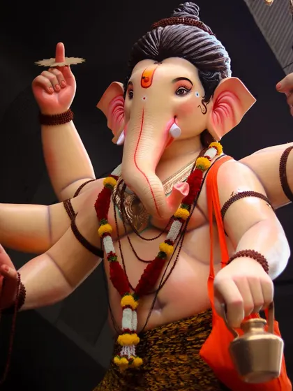 A detailed close up of a beautifully crafted Ganesh idol, highlighting the expressive features and intricate decorations.