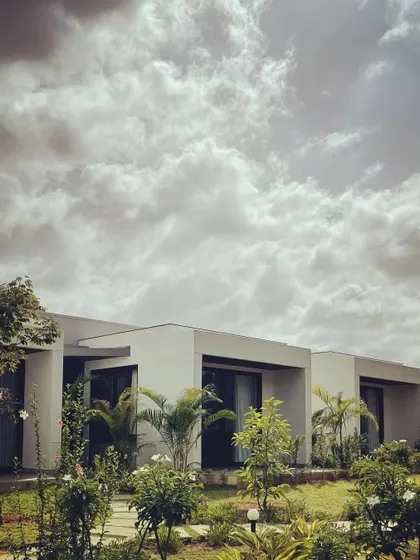 Our "Nisarg" project, with its clean lines and minimalist form, surrounded by a growing garden. The design allows each room to have a unique connection to the outdoors.