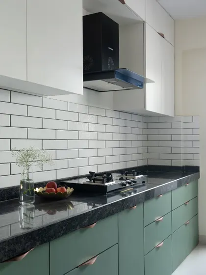This kitchen exudes timeless charm with classic white subway tiles. The dark forest green lower cabinets create a striking visual contrast against the white upper cabinets, adding depth and character.