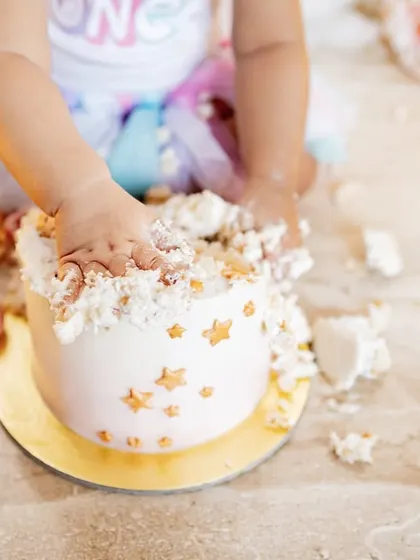 Tiny hands and feet covered in cake. These are the sweet, messy details you'll want to remember from your baby's first birthday celebration.