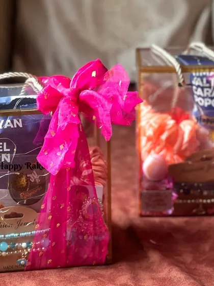 A clear view of the illuminated Rakhi hampers, showcasing the contents which include popcorn, jewelry, and scrunchies.