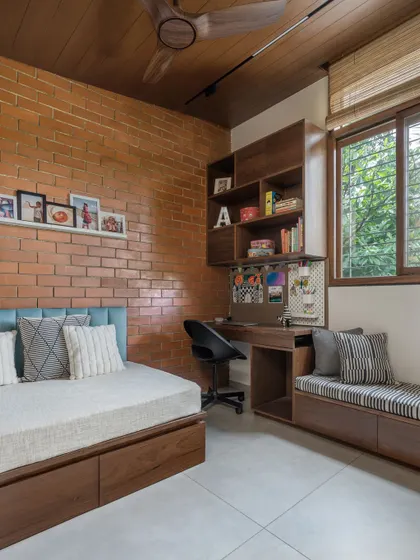 For our own son's room, his only request was a brick wall. We paired the exposed brick with a custom wooden bed and a built-in study unit to create a cool and cozy space.