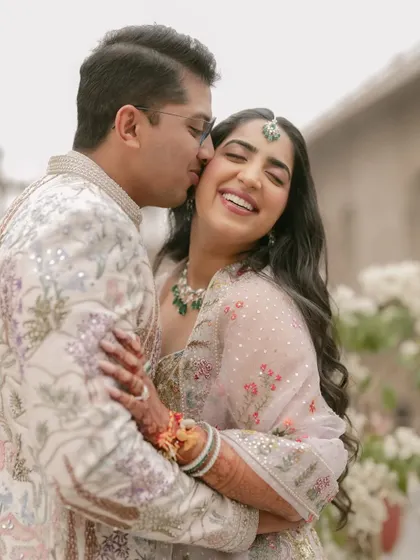 Pure, unadulterated happiness. This candid moment captures the essence of a pastel-themed celebration. The couple's coordinated Rahul Mishra outfits and the soft, natural light create a picture of effortless romance.