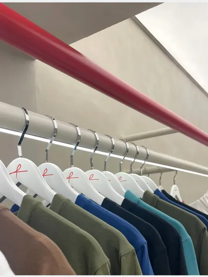 Detail is key in retail design. At the ARKS store, we used a continuous red rod for hanging apparel, which not only creates a flexible display system but also guides the customer's eye through the space.