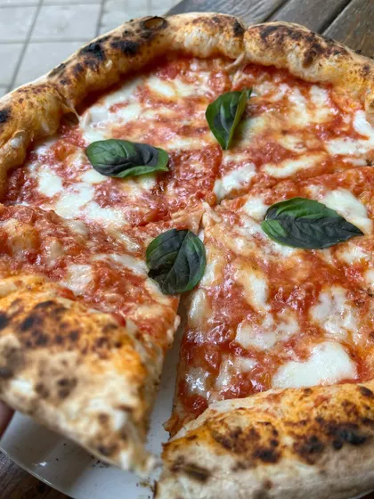 Grabbing a slice of our classic Margherita. The perfect bite.