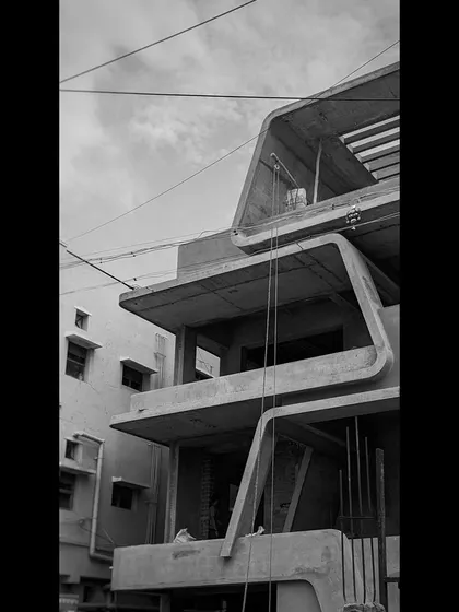 The raw concrete form of a building in progress, showcasing the bold, angular lines and cantilevered balconies that define its architectural character.