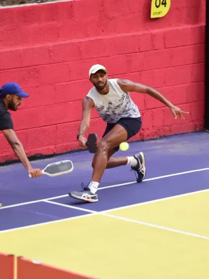 Two players lunge for a shot during a fast-paced doubles rally. Our tournaments are filled with moments of incredible athleticism and teamwork.