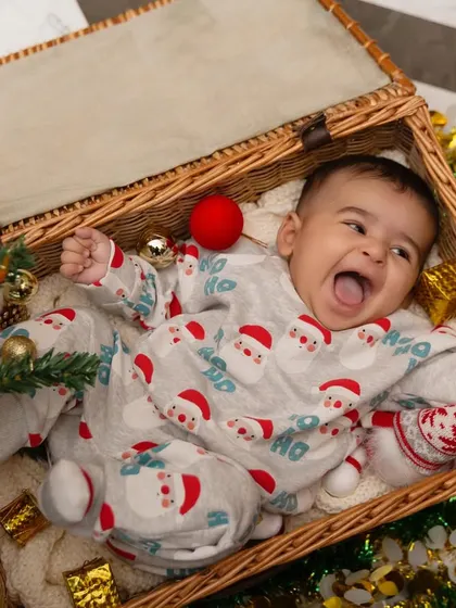 The pure joy of Christmas, captured in a basket of festive cheer. This little one's excited expression is what the holiday season is all about.