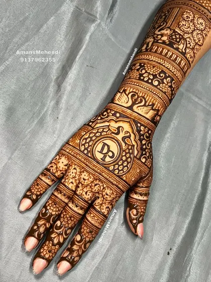 A personalized back-hand bridal design with the initials 'D' and 'P' at the center, surrounded by swans and floral bands.