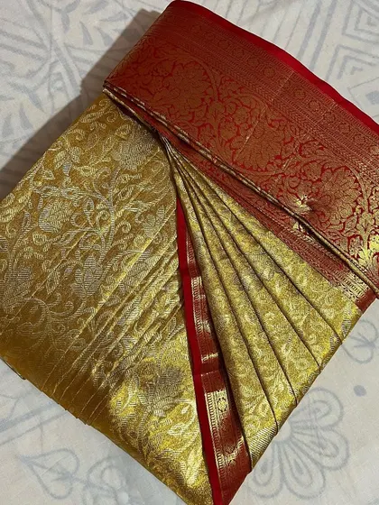 This gold bridal saree with a red border is now perfectly pleated. My service is a huge help for brides during their busy wedding schedule.