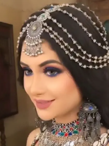 A model showing off a beautiful oxidised silver mathapatti with multiple chains. This hair accessory is perfect for a festive or bohemian look.