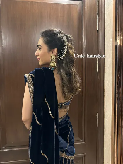 A close-up of a cute hairstyle for a wedding, featuring a passa hair accessory with a navy blue velvet saree.
