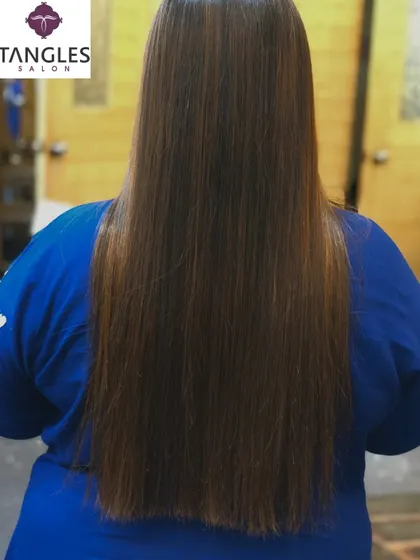 Here is the same gold chocolate balayage on another client, demonstrating the versatility of the color. The long, straight hair provides a perfect canvas to display the smooth transition from the dark roots to the lighter ends.