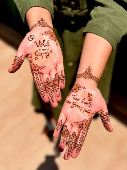 An angled view of the personalized engagement mehendi, showing how the names and quotes are beautifully integrated.