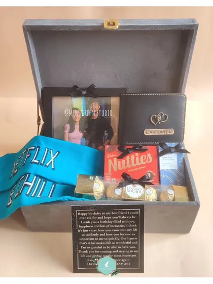 For a best friend's birthday, I combined fun and function. This hamper includes "Netflix & Chill" socks, a personalized wallet, a photo frame with a cherished memory, and his favorite chocolates.