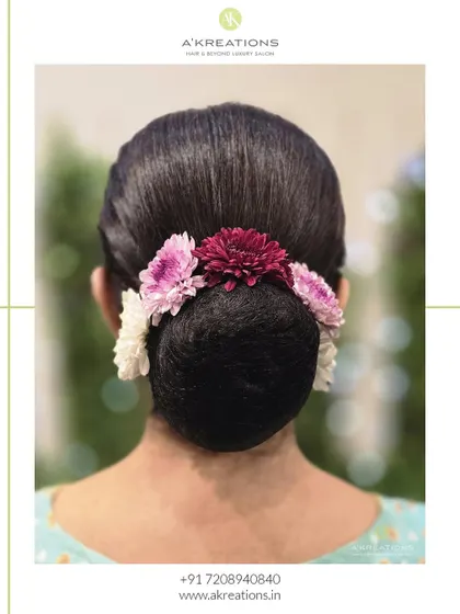 A timeless and elegant floral bun. This sleek, perfectly crafted updo is adorned with fresh flowers, making it ideal for weddings and traditional events.