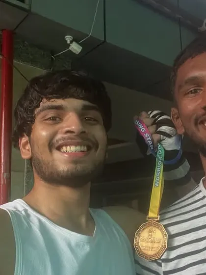 A smiling moment with a teammate after winning a medal. The joy of victory is best when shared.