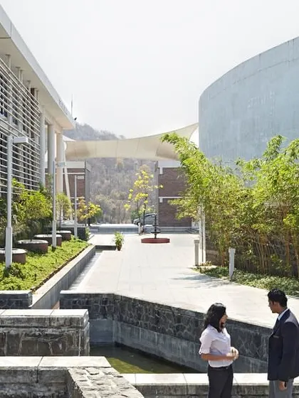 A view of the landscaped pathway at Symbiosis International University, Pune. The design integrates water channels and native plants, creating a pleasant microclimate and offering students a tranquil space for informal discussions and relaxation between classes.