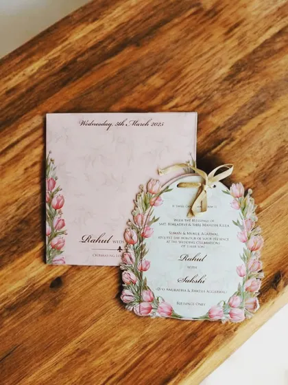 A beautiful laser-cut invitation with a pink tulip floral frame, die-cut to create a unique and memorable shape.