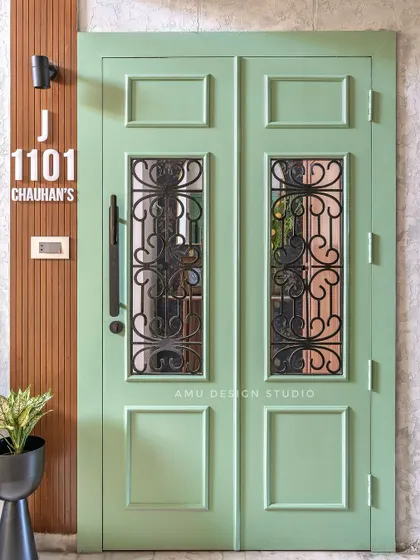 A beautiful custom-made main door in a refreshing mint green. The design includes classic paneling and intricate black metal grillwork, offering both security and style.