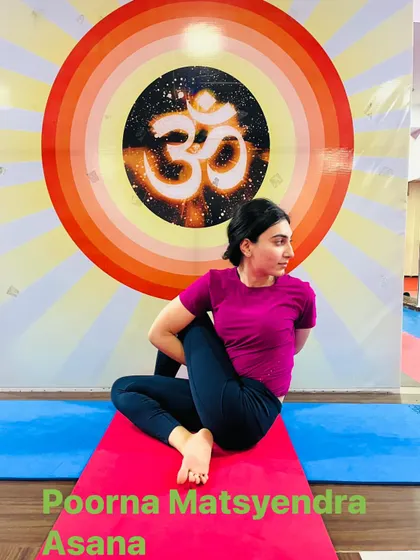 The full expression of the seated spinal twist, Poorna Matsyendrasana. This advanced pose requires significant flexibility in the spine and hips.