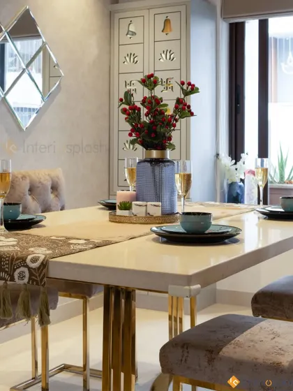A close-up of the elegant dining table setting. The combination of the marble top, gold accents, and fine dinnerware creates a sophisticated atmosphere for special occasions.