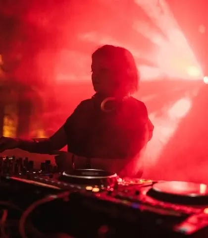 A silhouette of me DJing, surrounded by red smoke and a single spotlight. This atmospheric photo captures the mood of a deep techno set in a dark, underground club.