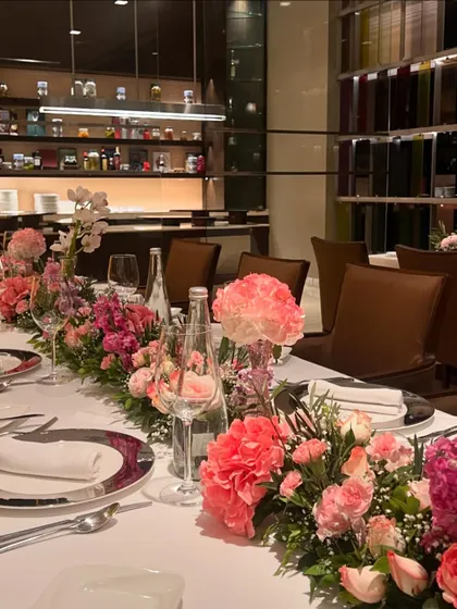 Elegance in every detail. For an intimate dinner, we created a stunning tablescape with a lush runner of pink carnations, roses, and hydrangeas, transforming the restaurant space into a sophisticated floral haven.