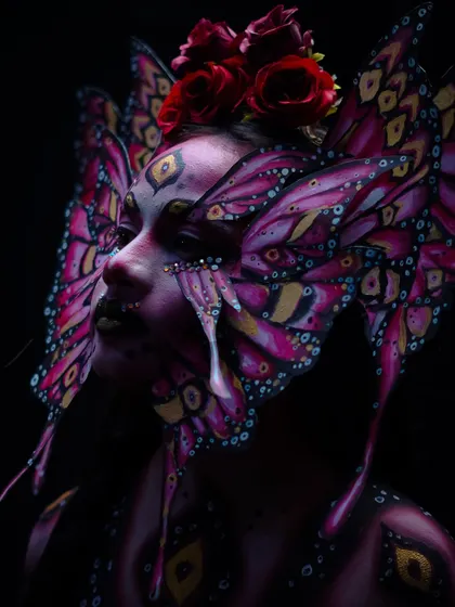The dark, moody lighting in this shot adds a dramatic and mysterious element to the butterfly look.
