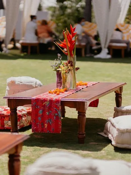 Low seating with colorful kantha-work runners and floor cushions at our 'Rajasthani Folklore' Mehendi, creating a relaxed and traditional 'baithak' style lounge.