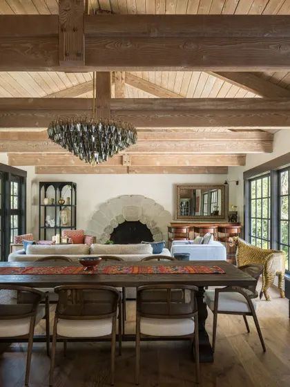 A wide shot of the great room in the Saratoga residence, capturing the impressive scale of the space with its vaulted wood-beamed ceiling and large open-plan layout.