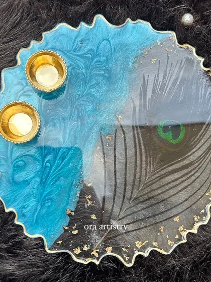A stunning top-down view of the peacock feather resin platter, complete with holders for small candles or diyas.