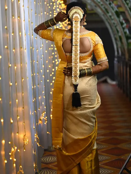 A beautiful shot of the back of Pooja's bridal blouse, showing the intricate detailing and the perfect fit that complements her traditional hairstyle.