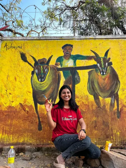 A joyful moment sitting with the completed cultural mural in Dharwad. This artwork, depicting a traditional bull race, is my tribute to the vibrant spirit of the region.
