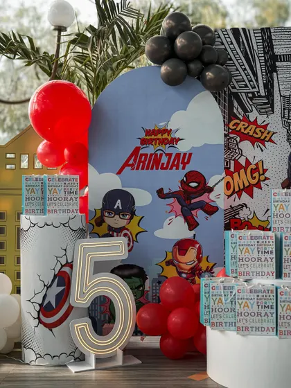 A dynamic shot of the superhero-themed birthday party. The large "5" neon number and character cutouts create a fantastic focal point for photos and add to the celebratory atmosphere.