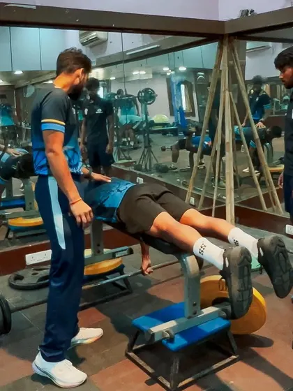 An athlete performs a prone hamstring curl on a bench. Targeting the hamstrings directly is a key part of our injury prevention strategy, especially for fast bowlers and sprinters.