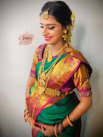 The mom-to-be looking serene and happy. The green and pink silk saree is a classic choice, and the makeup complements it perfectly.