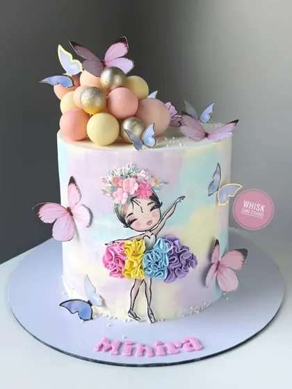 A beautiful ballerina cake for your loved one. This cake features a watercolor effect and is decorated with a ballerina print and a cascade of edible butterflies.