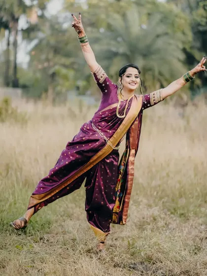 A playful, dancing pose from the bride in her beautiful purple Nauvari saree.