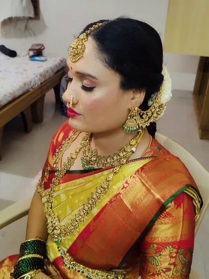 Our happy client Usha, ready for her big day. She is wearing a complete antique-finish bridal set, including a choker, long necklace, jhumkas, and a traditional maang tikka that beautifully frames her face.