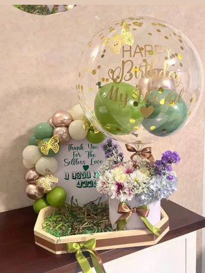 We created this beautiful green and white themed tray for a mother's birthday. It includes a floral arrangement, a personalized message board, and a custom confetti balloon.